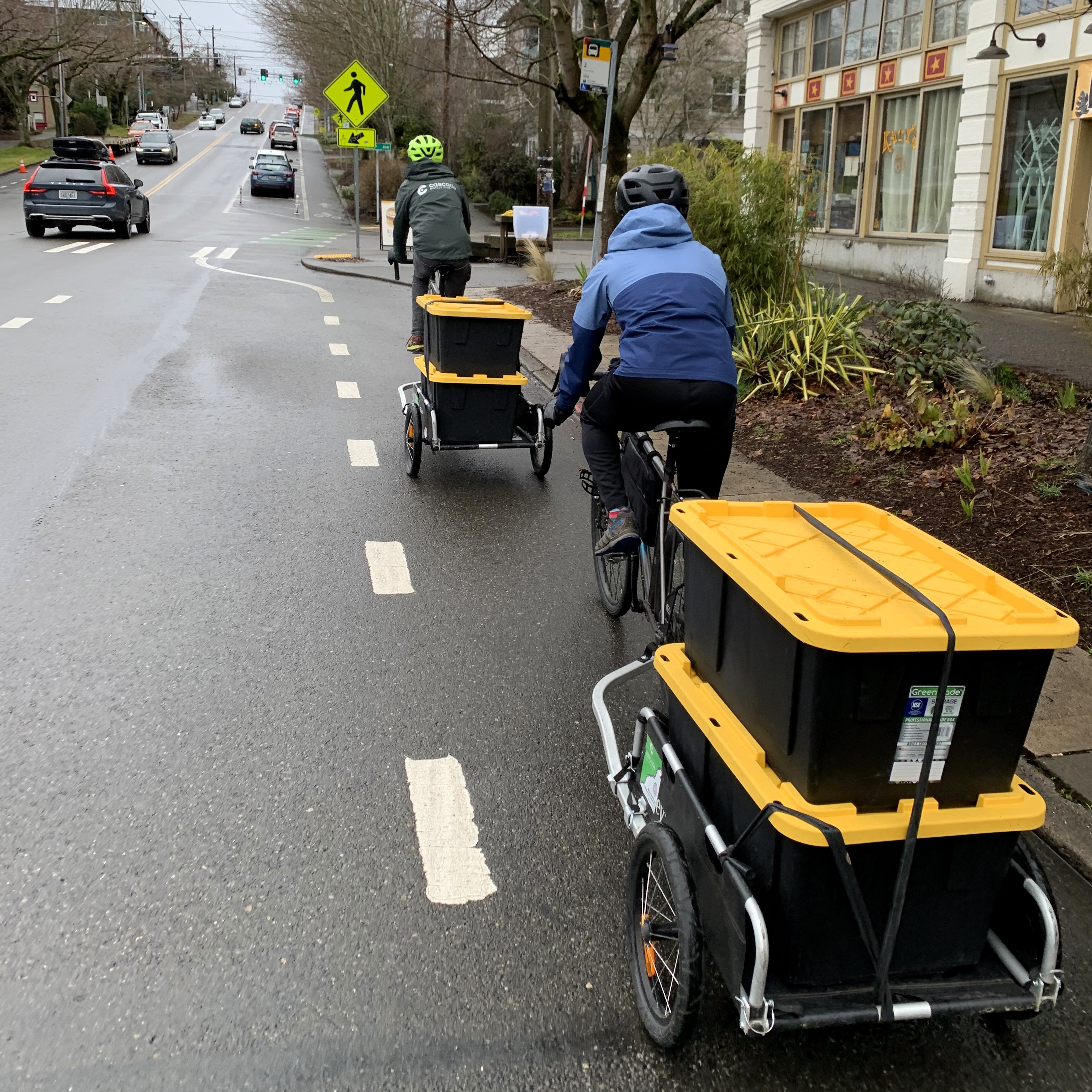 Two PRP riders pull bins of food collected at PCC Community Markets to Byrd Barr Place Food Bank